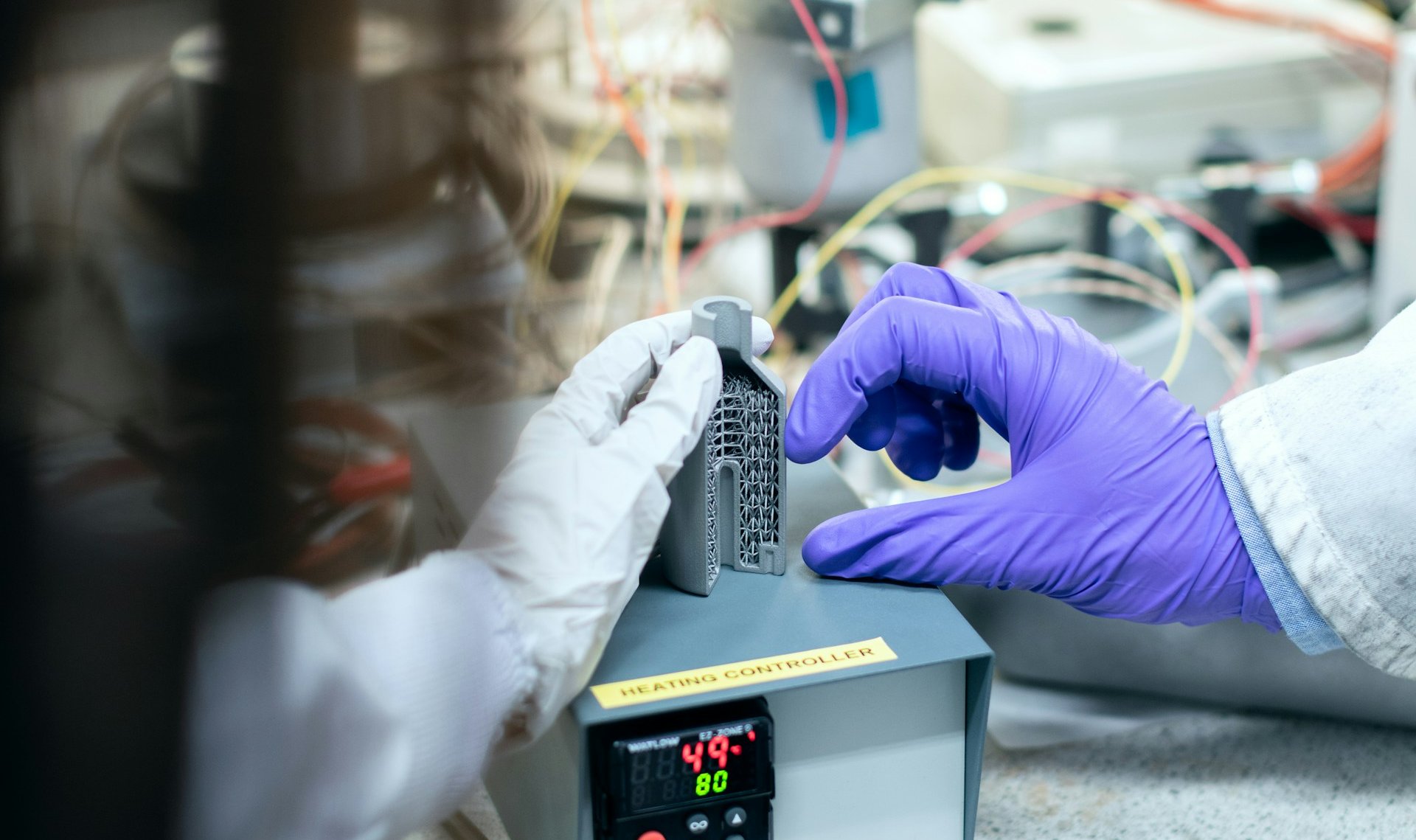 Lab workers reviewing cross cut cut honeycomb part